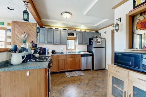 a kitchen with wooden cabinets and stainless steel appliances at Nimba Cabin in Oakland