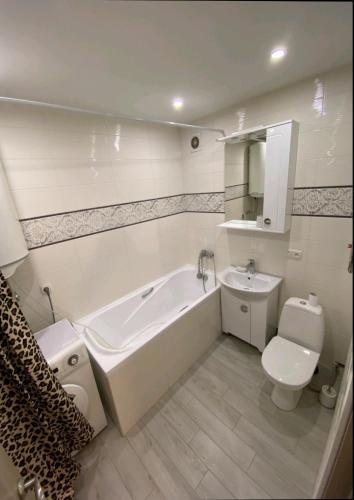 a bathroom with a tub and a toilet and a sink at Центр Пассаж ЦУМ in Dnipro