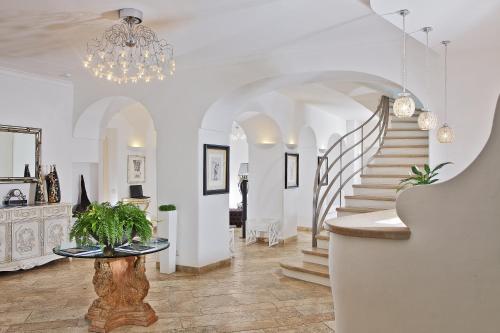 a living room with a staircase and a chandelier at Hotel Orsa Maggiore in Anacapri