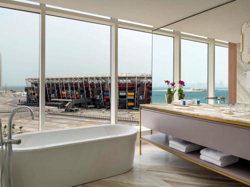 ein Badezimmer mit Badewanne und großem Fenster in der Unterkunft Rixos Gulf Hotel Doha in Doha