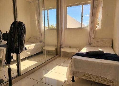 a bedroom with a mirror and a bed with a fan at Apartamento Moto Chico Petrolina in Petrolina