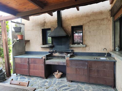 an outdoor kitchen with a stove and a sink at Los jardines de Osseja in Osséja