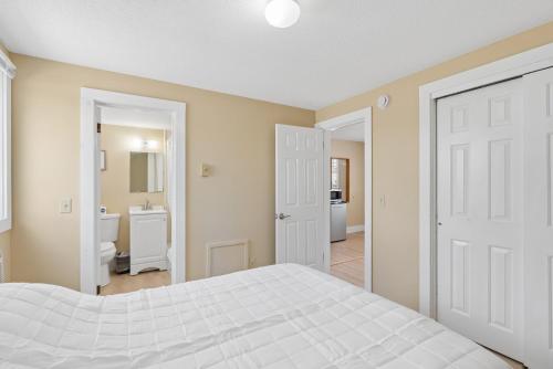 a bedroom with a white bed and a bathroom at The Inn at Soho Square in Old Orchard Beach