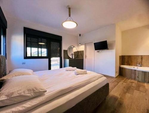 a bedroom with a large bed and a bathroom at שובל shoval in Yavneʼel