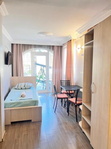 a bedroom with a bed and a table and chairs at Deluxe Family Stay Near The Beach in Kvariati