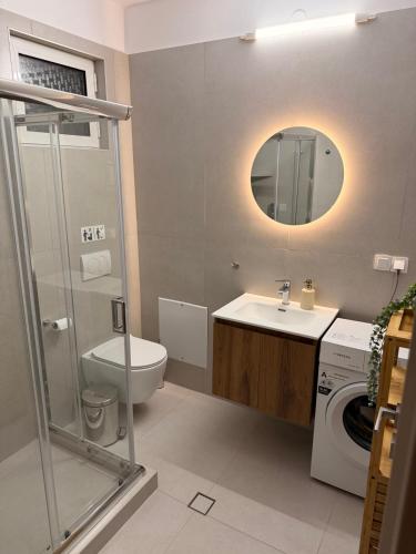 a bathroom with a sink and a toilet and a mirror at Olea House in Alexandroupoli