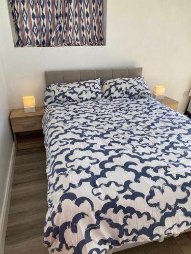 a bed with a blue and white comforter and two pillows at Room in Cappa in Kilrush