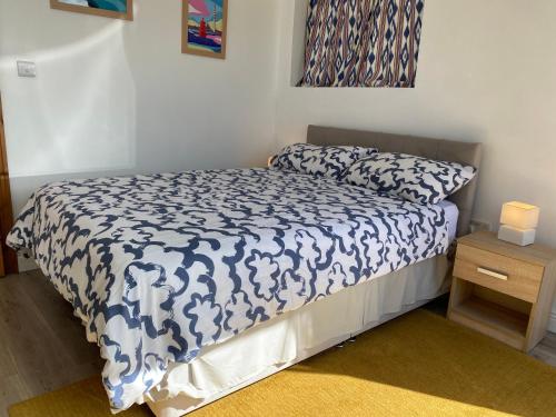 a bedroom with a bed with a blue and white comforter at Room in Cappa in Kilrush