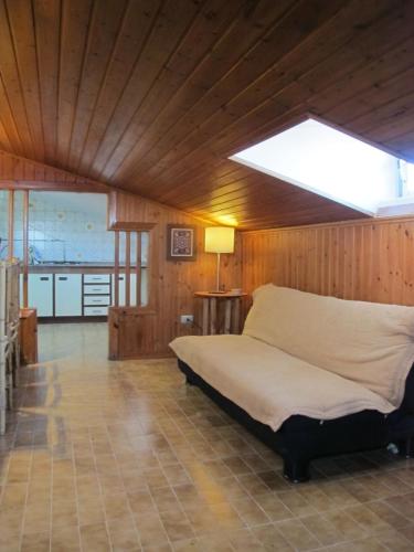 a bedroom with a bed in a wooden room at Ático Yuly in Rianjo