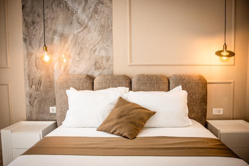 ein Schlafzimmer mit einem großen Bett und weißen Kissen in der Unterkunft Emaar in Ulcinj