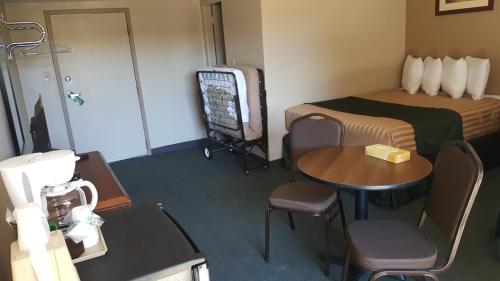 a hotel room with a bed and a table and chairs at Lake Powell Canyon Inn in Page