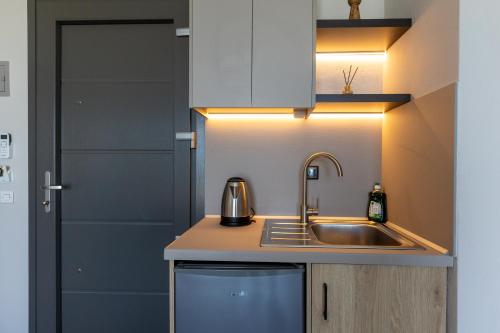 a small kitchen with a sink and a door at Kastalia Studios And APARTMENTS in Skala Potamias