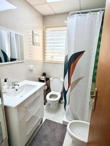 a bathroom with a sink toilet and a shower curtain at Casa Carlos de Novelda in Novelda