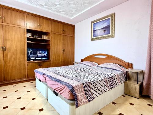 a bedroom with a bed and wooden cabinets at Casa Carlos de Novelda in Novelda