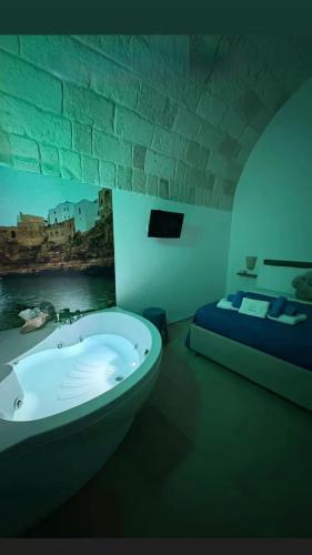 a room with a bath tub and a bed at Le Perle di Bà - Suites with Jacuzzi in Polignano in Polignano a Mare