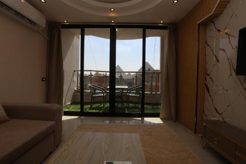 a living room with a couch and a large window at Sacred Pyramids Stay in Cairo