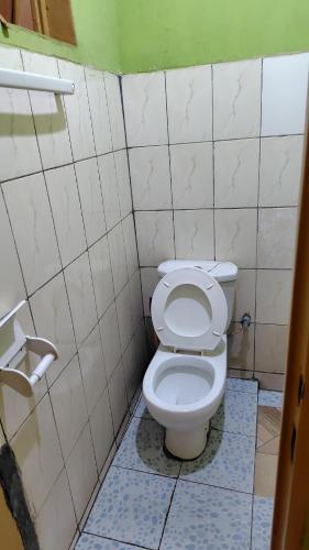a bathroom with a white toilet in a stall at Life Vision Hotel in Huye