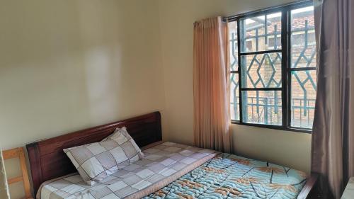 a small bedroom with a bed with a window at Life Vision Hotel in Huye