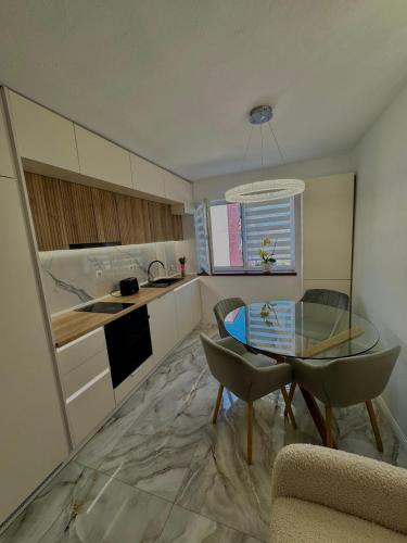 a kitchen with a glass table and chairs in a room at Apartament Deluxe in Orăştie