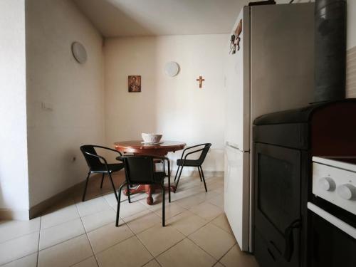 a kitchen with a table and chairs and a refrigerator at Spacious City Center Apartment for 6 - Steps from Hilton & Republic Square in Podgorica