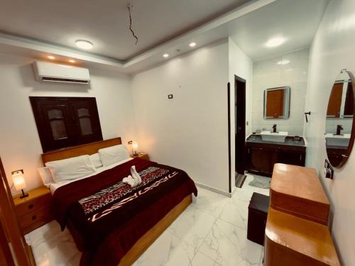a bedroom with a bed and a bathroom with a sink at private studio - djorff area in Al Aqālitah