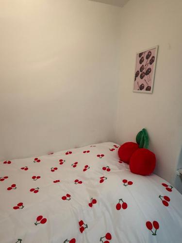 un letto con fiori rossi sopra in una camera da letto di Ciotat Cherry - au coeur de La Ciotat à 2 pas du port a La Ciotat