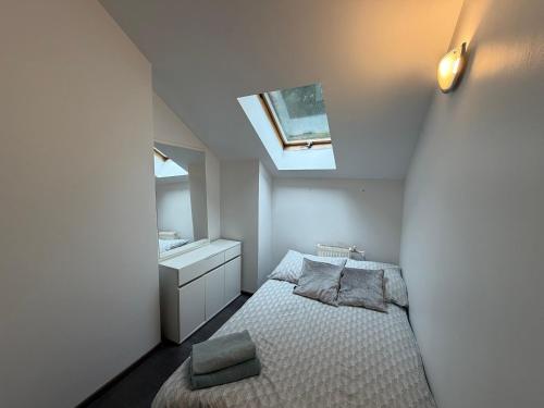 a small bedroom with a bed and a skylight at Glow Rooms in Gdynia