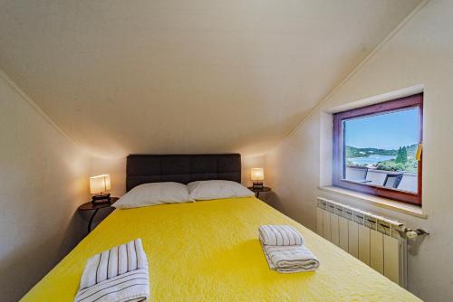 a bedroom with a yellow bed and a window at Rezidence Castello in Korčula