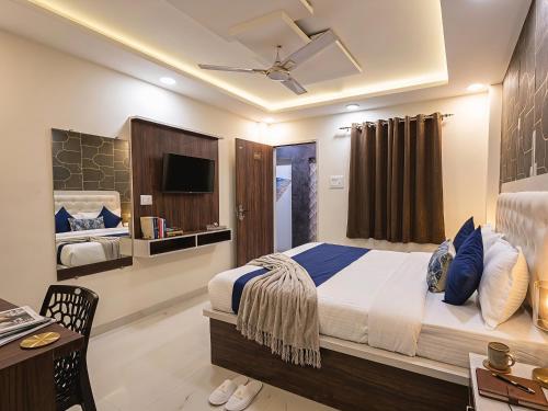 a bedroom with a bed and a desk and a television at Hotel Venus Inn in Indore