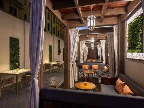 a hotel room with a couch and a table and a window at ibis Doha in Doha