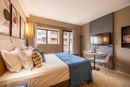 a hotel room with a bed and a table at APS - Alpha Stay By Anora Spaces in Barueri