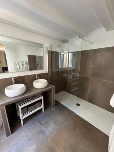 a bathroom with two sinks and a shower at Jolie maison de village à Grimaud in Grimaud