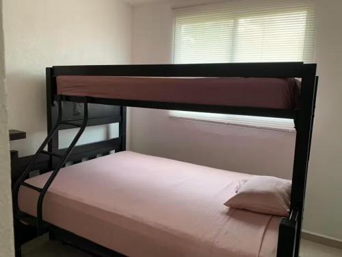 a bedroom with a bunk bed and a window at Marina Diamante - Ilse C in Acapulco