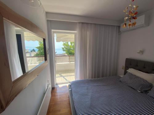 a bedroom with a bed and a large window at Irini Seaside Apartment in Paleo Tsifliki