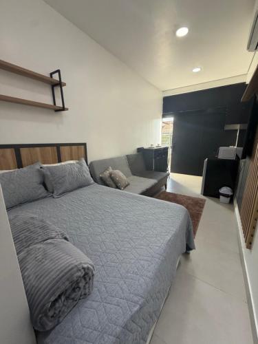 a bedroom with a large bed and a couch at Loft bem localizado na cidade! in Boa Vista