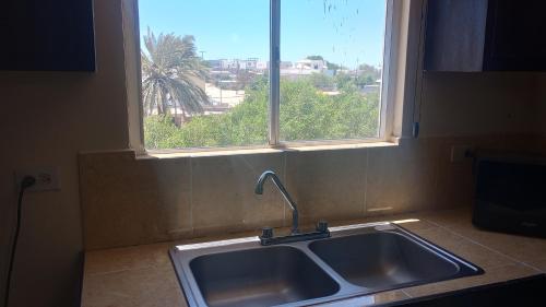 a sink in a kitchen with a window at Hotel palma de oro in Puerto Peñasco