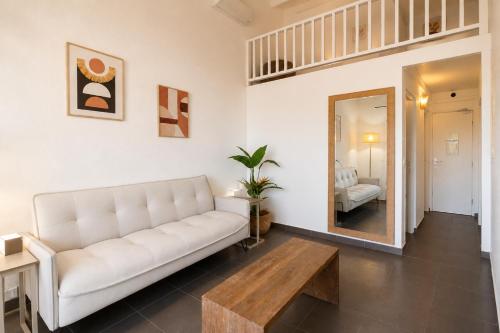 a living room with a white couch and a wooden table at Côté Golf Marina in Saint-François