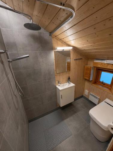 a bathroom with a toilet and a sink at Forest Cabin by the Water in Ålesund