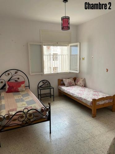 a bedroom with two beds and a window at Appartement S3 in Mahdia in Mahdia