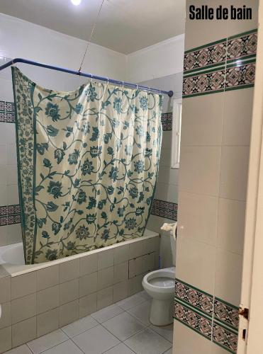 a bathroom with a shower curtain and a toilet at Appartement S3 in Mahdia in Mahdia