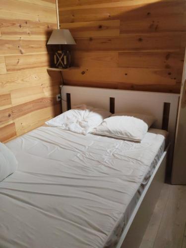 a bed with white sheets and pillows in a room at Casse blanche in Orcières