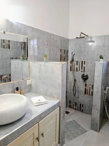 a bathroom with a sink and a shower at Villa DOUDOU in Somone