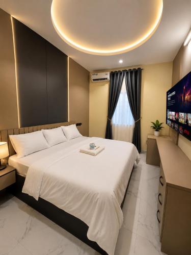 a bedroom with a large bed and a flat screen tv at Leebwill Hotel & Apartment in Eku