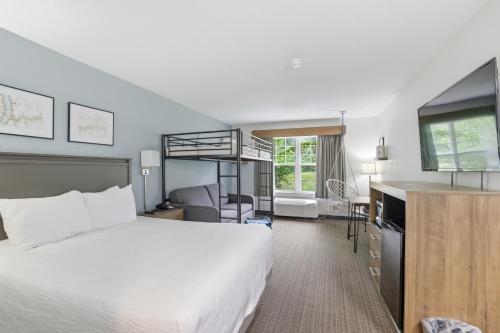 a hotel room with a bed and a television at The Commerce, Trademark Collection by Wyndham in River Falls