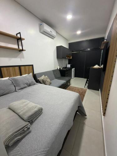 a bedroom with a bed and a living room at Loft Vip RR in Boa Vista