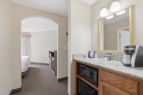 a hotel room with a sink and a mirror at The Commerce, Trademark Collection by Wyndham in River Falls
