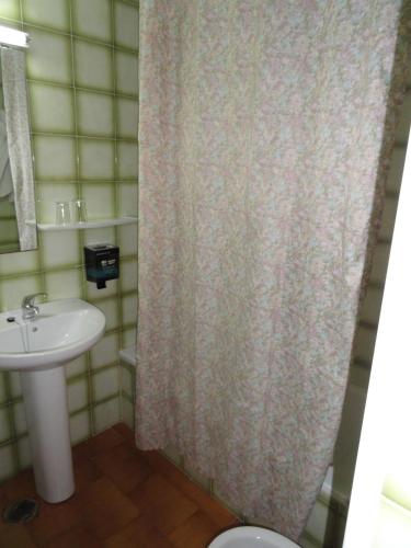 a bathroom with a sink and a shower curtain at Hotel El Coloso in Jerez de la Frontera