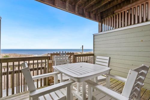 a table and chairs on the deck of a beach house at SW6 - Seawalk 6 in Kill Devil Hills