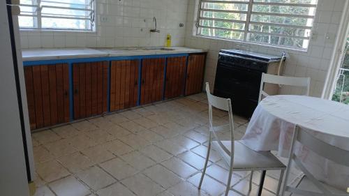 a kitchen with a table and a chair and a stove at Studio na Serra I in Itatiaia