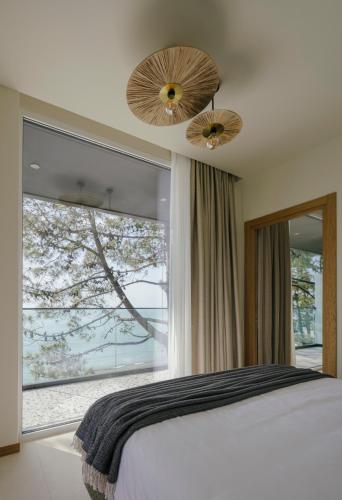 a bedroom with a bed and a large window at Buknari Hotel in Buknari